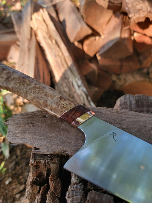 Rhymer Knives | 8 Chef Knives - African Blackwood + Rams Horn with Copper Bolster, showcased on a log, highlighting its hand-forged craftsmanship and superior handling features.