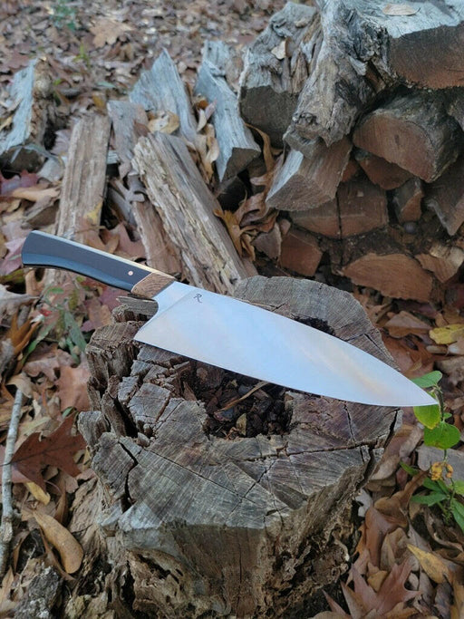 Rhymer Knives | 8 Chef Knives - African Blackwood + Rams Horn with Copper Bolster, hand-forged, showcased on a stump, highlighting precision craftsmanship and distinctive design.