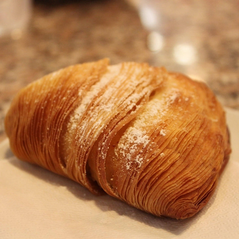 Nicola's Marketplace | Individual Mini Italian Sfogliatelle Pastries: Flaky, shell-shaped pastry with thin layers, dusted with sugar, filled with ricotta and orange peel.
