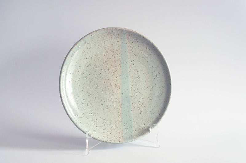 RachaelPots - Dessert Plate: Sage. Speckled ceramic plate with a faint stripe, displayed upright, perfect for desserts. Hand-thrown, lead-free, microwave and dishwasher safe.