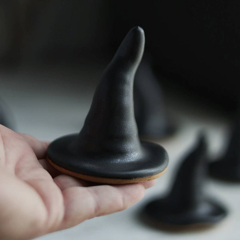 Hand holding Gravesco Pottery's Black Witch Hat, a ceramic ring holder or decor piece, showcasing its handcrafted details for Halloween enthusiasts.