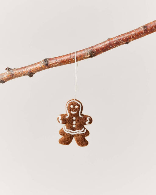 Farmhouse Pottery - Felted Gingerbread Ornament: Lady, handcrafted from 100% wool with white icing detail, hangs from a branch, perfect for holiday decor.