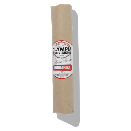Olympia Provisions - Loukanika Salami wrapped in butcher paper; a Greek-inspired salami with cumin, garlic, and orange zest, showcasing natural mold on its casing.