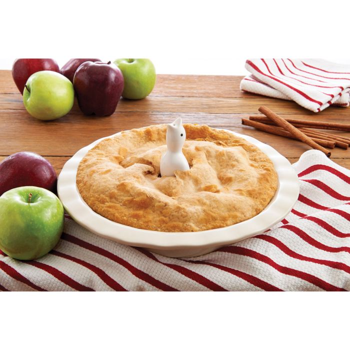 Harold Imports | Pie Bird nestled in a pie, surrounded by apples, highlighting its use for venting steam during baking.