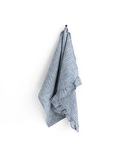 MagicLinen - Ruffle trim tea towel in dusty blue, hung on a hook, showcasing its soft linen texture and practical hanging loop for kitchen use.