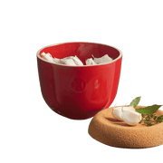 Emile Henry Garlic Pot in Burgundy, showcasing a ceramic bowl with garlic cloves, herbs, and a vented lid for optimal garlic storage, handcrafted in France.