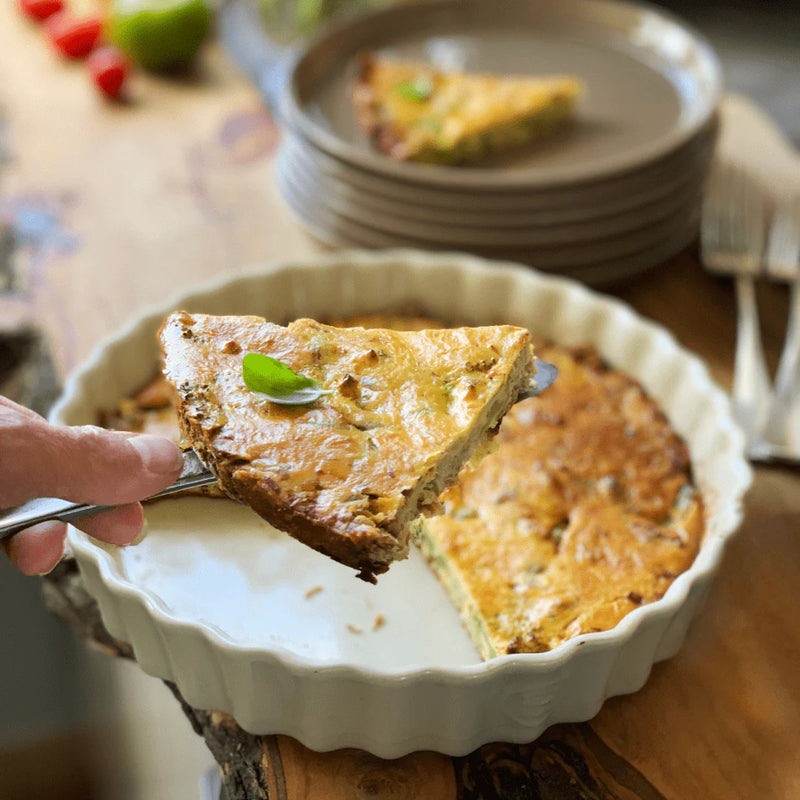 A slice of savory quiche in Emile Henry's Deep Tart Dish, Clay, 2.1 QT, showcasing its baking prowess and elegant presentation at Athens Cooks.