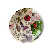 Bee's Wrap - Assorted 3 Pack - Meadow Magic: A bowl of fresh salad partially covered with floral-patterned, vegan, plant-based beeswax wrap, featuring pollinator-themed design.