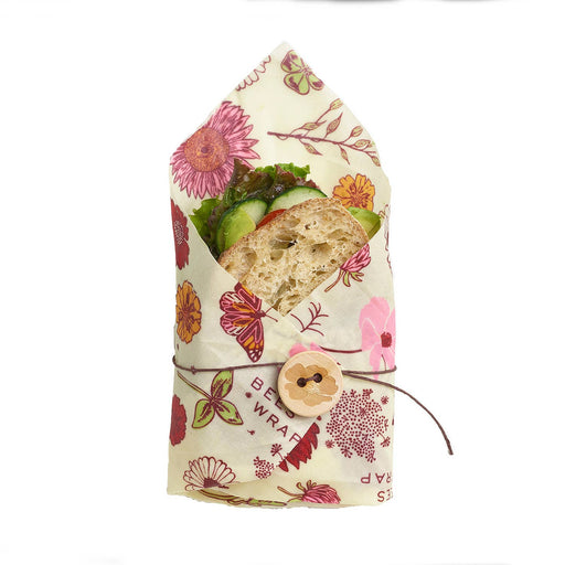 Bee's Wrap - Sandwich Wrap - Meadow Magic, Vegan Wax secures a half sandwich with crusty bread, lettuce, cucumber, and tomato using a floral beeswax wrap with wooden button closure.