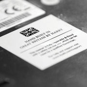 Close-up of Dualit | 2 Slice Classic Toaster, Matt Black, featuring a label HAND BUILT IN GREAT BRITAIN BY HARRY highlighting craftsmanship and repairability.