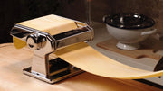 Marcato | Atlas 150 Pasta Maker (Powder Grey) shown with dough, illustrating its manual operation for crafting homemade lasagne, fettuccine, and tagliolini.