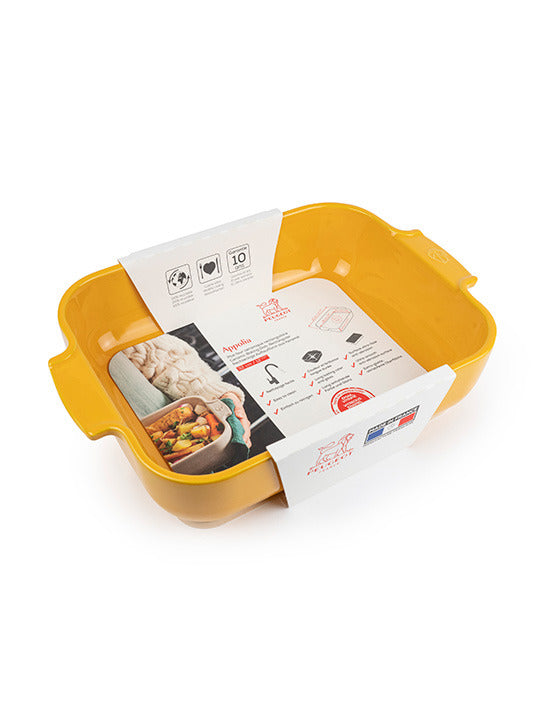 Peugeot | Appolia Rectangular Baking Dish, Saffron Yellow, shown with side handles and retail banding highlighting its versatile cooking features and durable, easy-to-clean enamel.