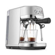Breville | Bambino Plus espresso machine pulling two shots into glass cups, featuring a portafilter, steam wand, and control panel for precise home brewing.