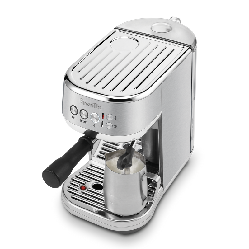 Breville | Bambino Plus espresso machine with portafilter and steam wand frothing milk, showcasing professional-grade features for home baristas, available at Athens Cooks.