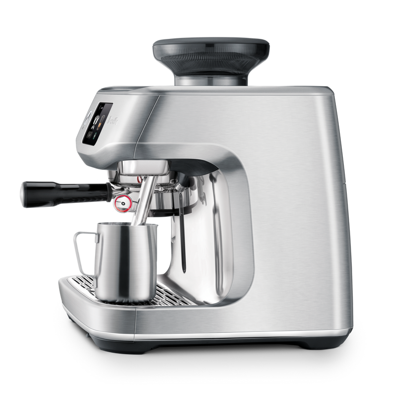 Breville | The Oracle Jet espresso machine features an integrated grinder, portafilter, and steam wand, with a milk pitcher ready for frothing.