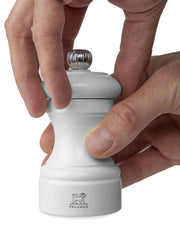 Hands holding Peugeot | Bistro Pepper Mill, Pearl Grey, showcasing its sleek design and iconic logo, perfect for enhancing elegant kitchen decor with lifetime-warranted functionality.