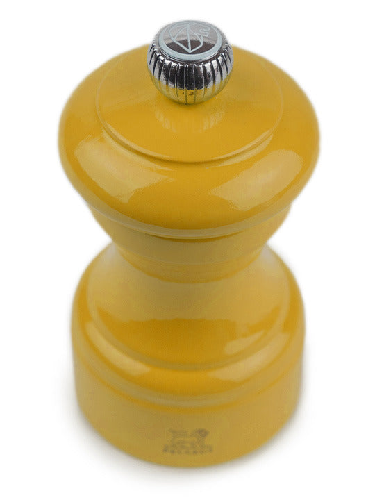 Peugeot | Bistro Pepper Mill, Saffron in glossy mustard yellow with a metal adjustment knob, showcasing elegant French craftsmanship from sustainably sourced wood.