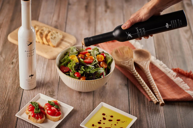 Ancient Olive Trees | Balsamic Vinegar being poured into a salad bowl, highlighting its unique bottle design and culinary use.