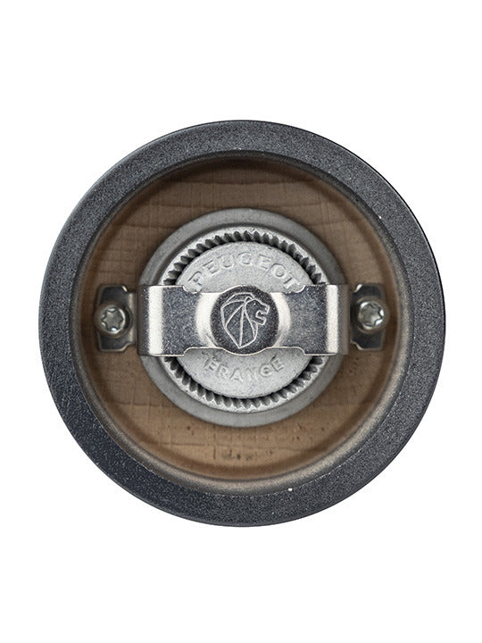 Close-up of Peugeot | Bistro Pepper Mill 4 Inches, showcasing the metal burr and adjustment knob within the wooden body, featuring the Peugeot France logo.