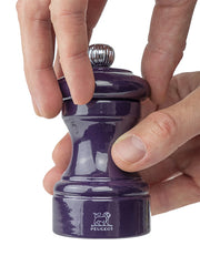 Peugeot | Bistro Salt Mill, Eggplant, being used to grind peppercorns, showcasing its elegant design and craftsmanship, ideal for enhancing culinary experiences.