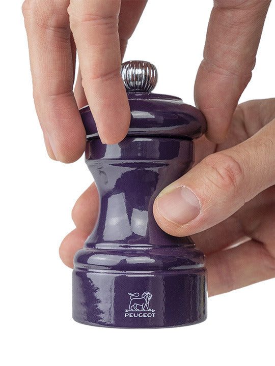 Peugeot | Bistro Salt Mill, Eggplant, being used to grind peppercorns, showcasing its elegant design and craftsmanship, ideal for enhancing culinary experiences.