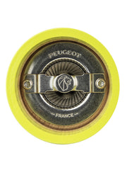 Peugeot | Bistro Salt Mill in Green Pistachio, showcasing its iconic conical metal burr mechanism, viewed from above, set within a yellow-painted wooden housing.