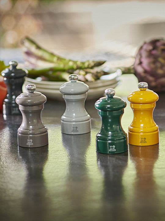 Peugeot | Bistro Salt Mill, Saffron, part of a glossy tabletop spice mill set, ideal for enhancing any kitchen with its timeless design.