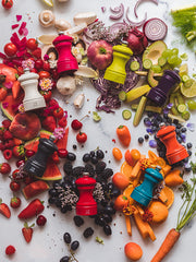 Peugeot | Bistro Salt Mill, Pacific Blue, amid a rainbow of produce, showcasing its modern beech wood design, adjustable steel grinding mechanism.
