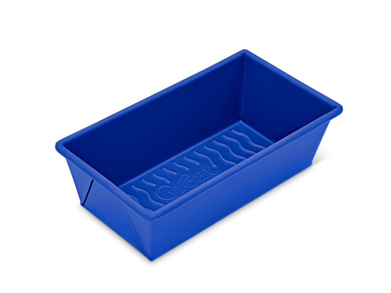 Great Jones | Breadwinner - Raspberry: A close-up of a blue rectangular baking dish with a wavy, corrugated bottom and nonstick ceramic coating for easy release.