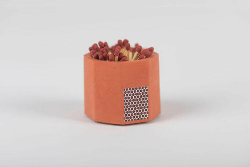 Close-up of the Tenn Prairie Match Holder, a hand-poured concrete vessel with a cork bottom, containing blue matches and a striker pad for easy lighting.