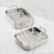 Hestan Provisions | Classic Roaster with Rack, 14.5 Inches, featuring two stainless-steel pans with wire racks on a marble countertop; ideal for versatile cooking.