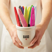 Kuhn Rikon Colori Paring Knife (Marshmellow) displayed in a ceramic pot with colorful clips, ideal for precise peeling and slicing tasks with its sharp Japanese stainless steel blade.