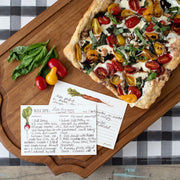 Hester & Cook | Farmer's Market Recipe Card displayed next to a pizza with tomatoes and basil on a wooden board.