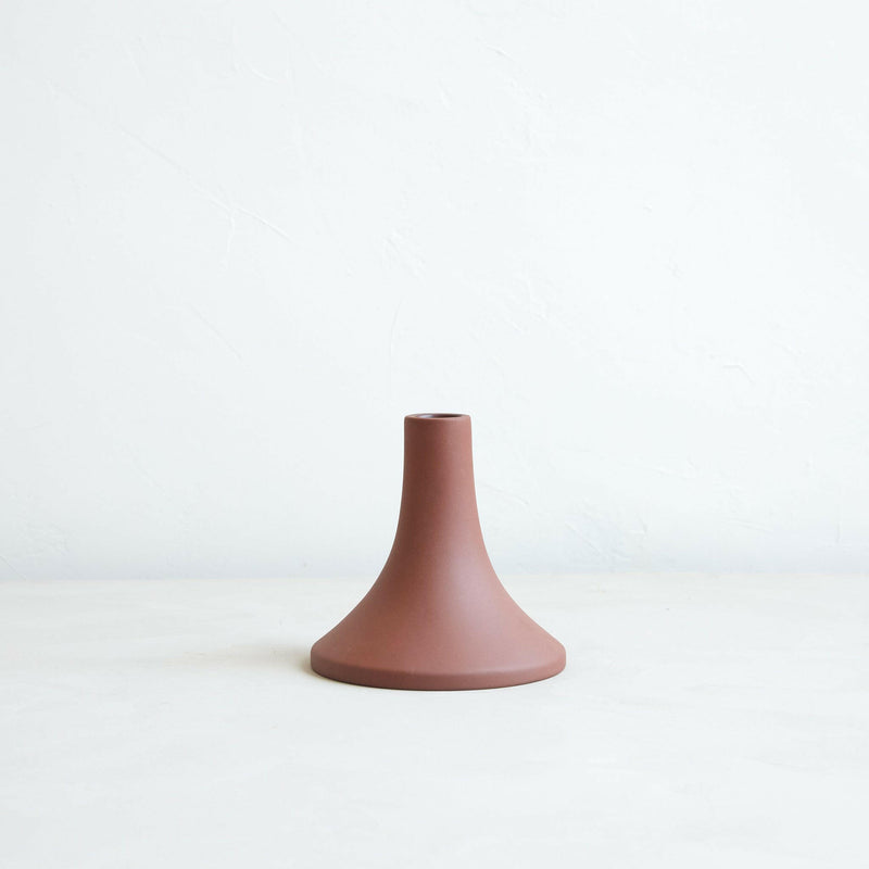 The Floral Society Grand Tall Earth candle holder, a hand-finished ceramic piece with a matte finish, fits standard taper candles, offering unique shape and size variations.