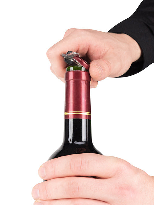 Hands using the Peugeot Clavelin Sommelier Corkscrew to open a wine bottle, showcasing its patented mechanism for effortless cork removal.