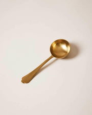 Essex Coffee Scoop with a scalloped handle and brushed gold finish, designed by Farmhouse Pottery, holds 2 tablespoons for perfect coffee measurements.