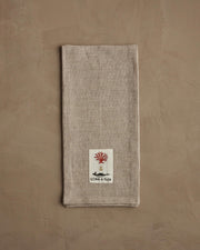 Coral & Tusk | Toy Workshop Tea Towel features a stitched patch with red coral, gold anchor, and black motif, perfect for a festive kitchen accent.
