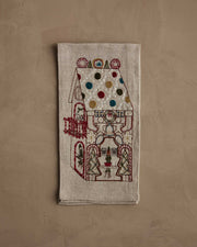Coral & Tusk | Cookie Workshop Tea Towel: A festive linen tea towel embroidered with a gingerbread house, featuring holiday motifs, perfect for adding Christmas cheer to your kitchen.