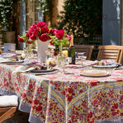 Caravan Home | 71 x 106 Red & Grey Tablecloth displayed on a table, featuring a floral design and surrounded by elegant tableware and a vase of flowers.