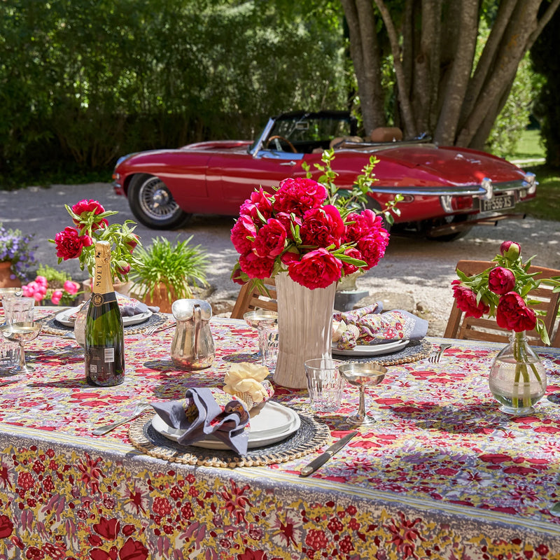 Caravan Home 71 x 106 Red & Grey Tablecloth on a table, adorned with plates and a floral centerpiece, capturing a French garden-inspired aesthetic.