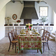 Caravan Home | 71 x 71 Red & Green Tablecloth elegantly drapes a dining table with floral settings, complementing the Jardin collection's lush, artisan-crafted design.