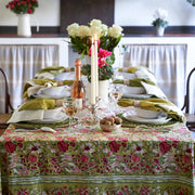 Caravan Home | 71 x 71 Red & Green Tablecloth elegantly displayed on a table with candles and flowers, showcasing its vibrant, handprinted design.