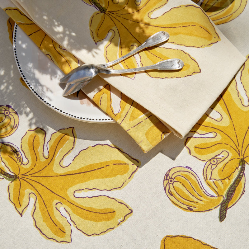 Caravan Home 19 x 19 Fig Citrine Napkins Set of 6 displayed with a spoon, highlighting the handprinted design ideal for elevating dining experiences.