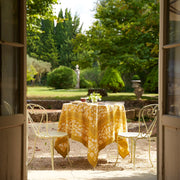 Caravan Home | 59 x 86 Forest Harvest Grey & Mustard Tablecloth set on an outdoor table, showcasing intricate fruit and foliage design.