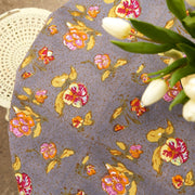 Caravan Home Pansy Red & Grey Tablecloth on a white chair, featuring intricate floral designs, handprinted on linen for a modern table setting.