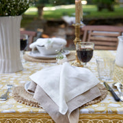 Caravan Home | 21 x 21 Stone Everyday Napkins Set of 4 displayed on a table with drinkware, highlighting the oversized linen napkins' craftsmanship and sophistication.