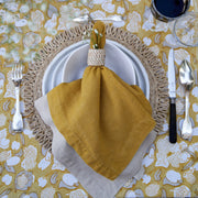 Forest Harvest Grey & Mustard Tablecloth displayed with an elegant place setting, showcasing its intricate design of fruits and foliage.