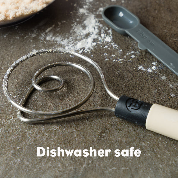 Brod & Taylor Dough Whisk on table with measuring spoon, designed for efficient dough mixing, available at Athens Cooks, a specialist kitchen store.