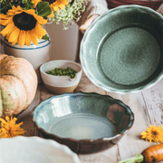 Emile Henry 175th Anniversary Pie Dish in Blue/Sable — lifestyle shot capturing warm sable exterior and blue interior