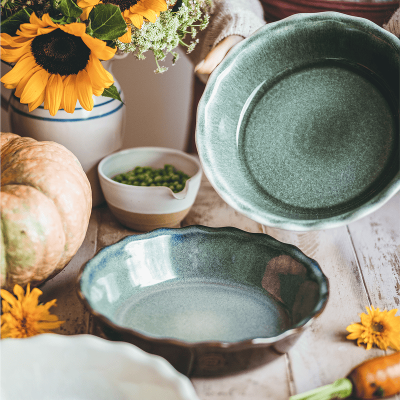 Emile Henry 175th Anniversary Pie Dish in Blue/Sable — lifestyle shot capturing warm sable exterior and blue interior